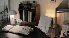 an open book sitting on top of a desk next to a lamp