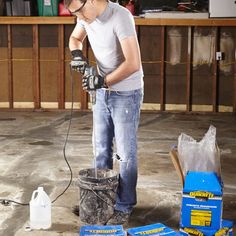 a man is sanding the floor with a power drill and other tools in front of him