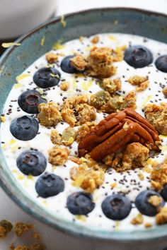 a bowl filled with yogurt, granola and blueberries