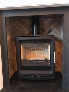 a wood burning stove sitting inside of a fireplace