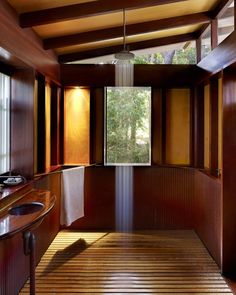 a bathroom with wooden walls and flooring next to a window