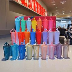 there are many different colored cups on the table