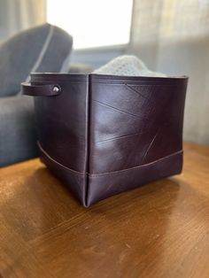 a brown leather purse sitting on top of a wooden table