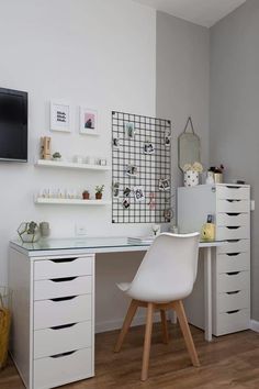 a white desk with drawers and a television mounted on the wall above it in a room