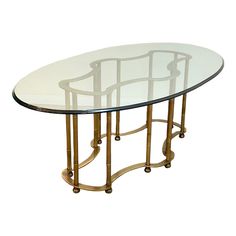 an oval glass table with gold metal legs