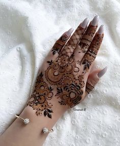 a woman's hand is decorated with hennap and jewels on it,