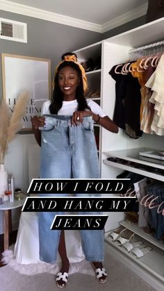 a woman standing in front of a closet holding up her jeans