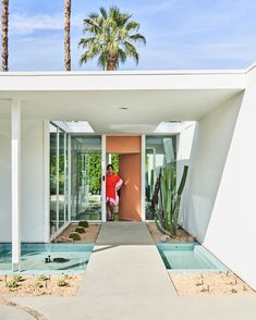 a man standing in the doorway of a modern house