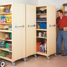 a man standing next to two wooden cupboards filled with food and other items on wheels