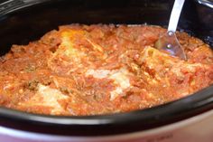 a crock pot filled with meat and cheese is being spooned into the slow cooker