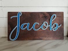 a wooden sign with the word jacob painted on it