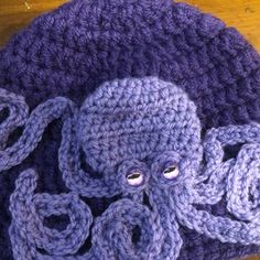 an octopus crocheted hat on top of a wooden table