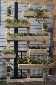 an outdoor planter made out of wooden pallets with plants growing on them and hanging from the side