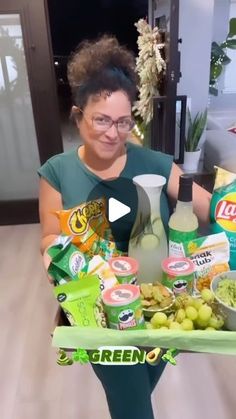 a woman holding a tray full of food and condiments in front of her