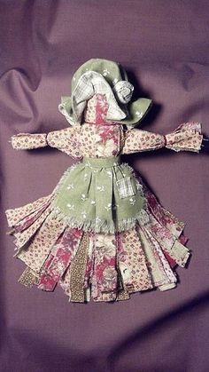 the doll is wearing a green dress with floral print on it and has a matching hat