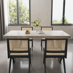 a dining room table with two chairs and a vase filled with flowers