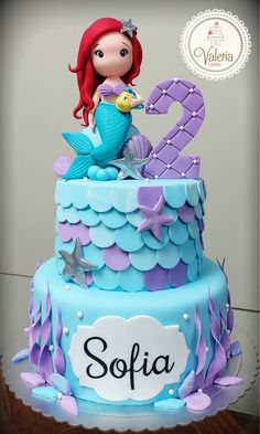 a blue and purple cake with a little mermaid on top