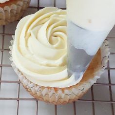 a cupcake being frosted with white icing