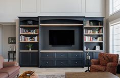 a living room filled with furniture and a flat screen tv mounted on a wall above it