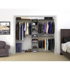 an open closet with clothes and shoes hanging on the wall next to a chair in front of a bed