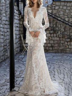 a woman in a wedding dress standing on a stone floor