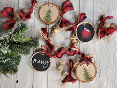 christmas ornaments are arranged on a white wooden table with red and black plaid ribbon around them