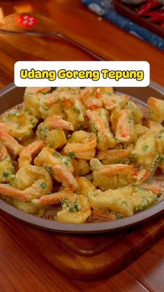 a bowl filled with shrimp and broccoli on top of a wooden table