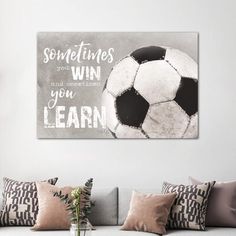 a living room filled with furniture and a soccer ball on top of a wall mounted canvas