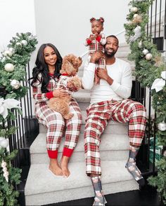 a man and woman are sitting on the steps with their dog wearing matching plaid pajamas