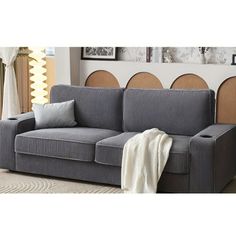 a gray couch sitting on top of a white rug