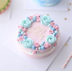 a pink and blue birthday cake on a table