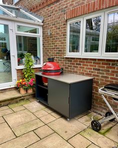 a bbq grill sitting on top of a patio next to a potted plant