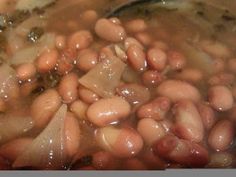 beans and onions cooking in a pot with a spoon