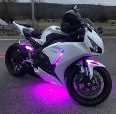 a white motorcycle with purple lights on it