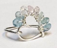 Aquamarine Ring  This beautiful Shaded Aquamarine Ring is hand forged into a gorgeous Heart Shaped Gemstone Ring in 925 Sterling Silver wire.  This Gorgeous Shaded Aquamarine gemstone has soft shades of pink, aqua, blue and clear crystal aquamarine gemstone.  A beautiful and unique stone.  You don't see the shaded aquamarine gemstone every day!  A must if you are looking for something different than the ordinary!  Beautiful gemstone for March Birthstone! Ring sizes available 3-16. Ring can be cu Crystal Aquamarine, Wired Jewelry, Jewelry Making Rings, Diy Jewelry Rings, March Birthstone Ring, Wire Jewelry Making, Malachite Pendant, Art Ring, Malachite Jewelry