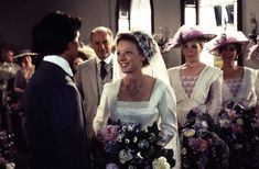 the bride and groom are talking to each other in front of their wedding party members