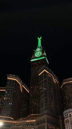 a clock tower lit up in the night sky with lights on it's sides