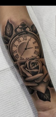 a black and white tattoo with a rose on the arm that has an alarm clock in it