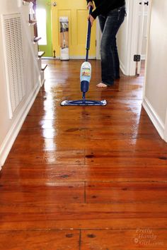 a woman is cleaning the floor with a mop