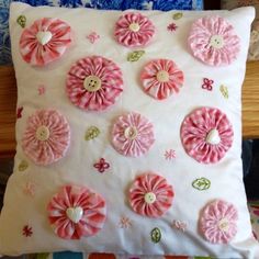 pink and white decorative pillows with buttons on them