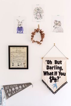 a white wall with some pictures hanging on it's side and other decorations around it