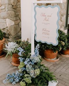 there is a sign that says welcome to the couple and their wedding ceremony in front of some potted plants