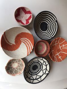 several bowls are arranged in the shape of spirals on a white table top with black and red accents