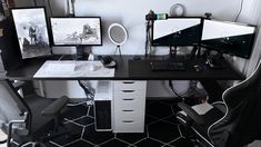 two computer monitors sitting on top of a desk next to a keyboard and monitor screen