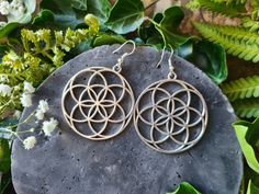 the earrings are made out of silver wire and have an intricate flower design on them