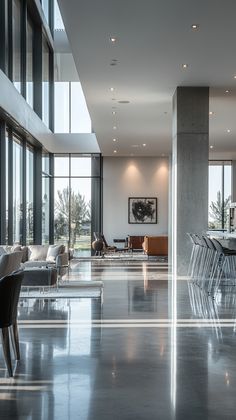 an empty room with chairs and tables in it's center, next to large windows