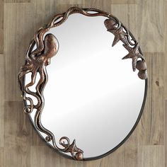 a mirror with an octopus and starfish design on the bottom, sitting on a wooden floor