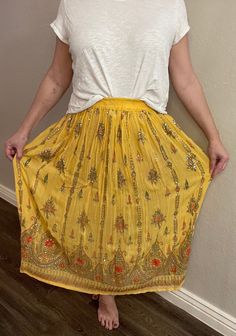 Be summer ready in this bright yellow vintage Indian skirt. With beautiful colors and detailing, this is a stunning piece that will spice up any wardrobe that may be looking for a breath of fresh air. The elastic waist and airy fabric also make this shirt very comfortable and perfect for spring and summer Bohemian Rayon Skirt For Summer, Gold Bottoms For Summer Festival, Traditional Summer Skirt For Vacation, Traditional Summer Vacation Skirt, Traditional Skirt For Summer Vacation, Gold Bottoms For Summer Vacation, Spring Beach Gold Bottoms, Traditional Beach Skirt For Summer, Traditional Summer Beach Skirt