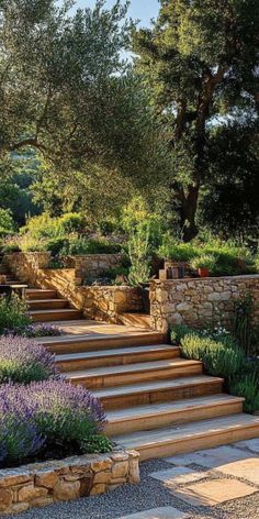 an outdoor garden with stone steps and lavenders in the foreground, surrounded by trees