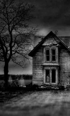 an old abandoned house in black and white with the moon shining through the clouds above it